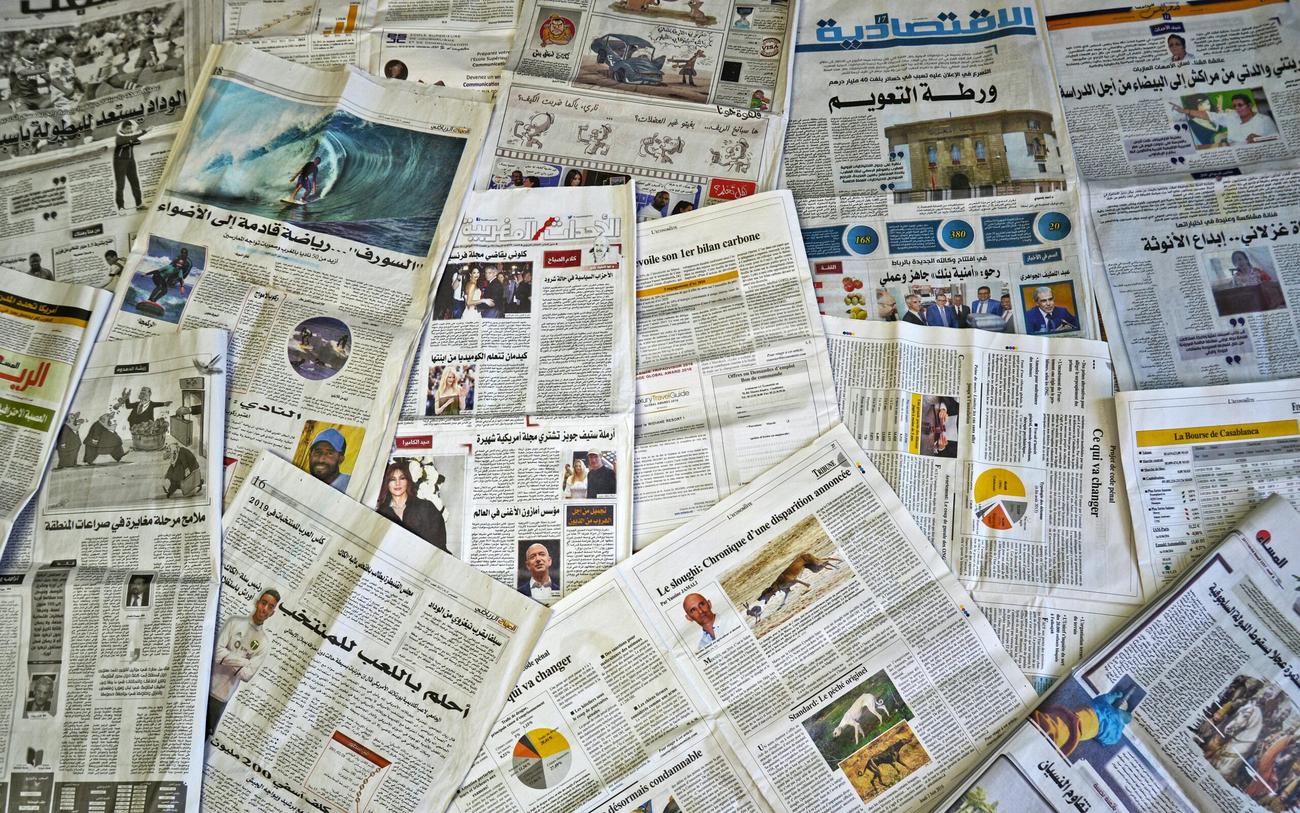 A variety of Arabic newspapers laid out, showcasing cultural and news diversity in Fès, Morocco.